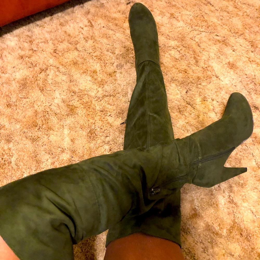 Knee high green boots with side side zippers.